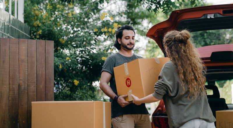 Casal carrega caixas para mudança