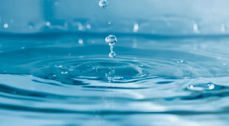 Imagem de gotas de água caindo em uma piscina, representando o Aquífero Guarani, um dos maiores recursos de água subterrânea do mundo e sua importância.