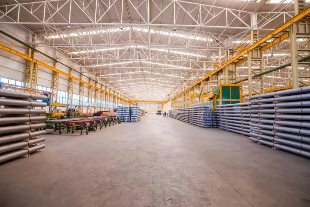 Imagem de um espaço amplo e bem iluminado em um galpão industrial, ideal para práticas de eficiência energética em galpões e indústrias.