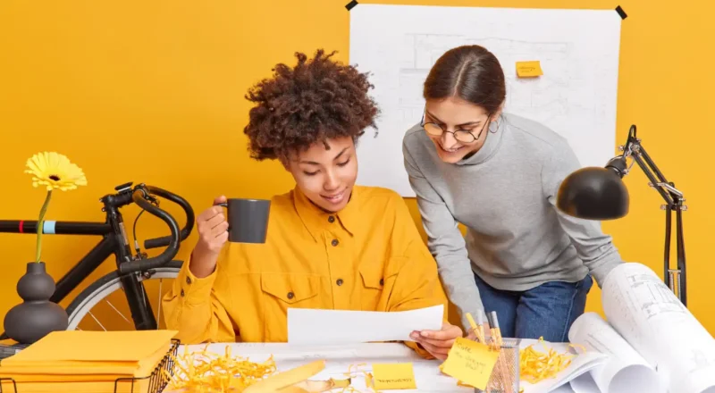 Profissional de marketing realizando reunião de planejamento com a equipe sobre o papel do marketing promocional na construção de marcas fortes, com materiais de trabalho e ambiente criativo.