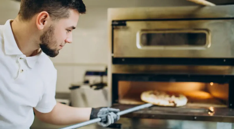 Homem verificando o forno de lastro para manutenção regular, essencial para garantir o funcionamento eficiente e seguro do equipamento.