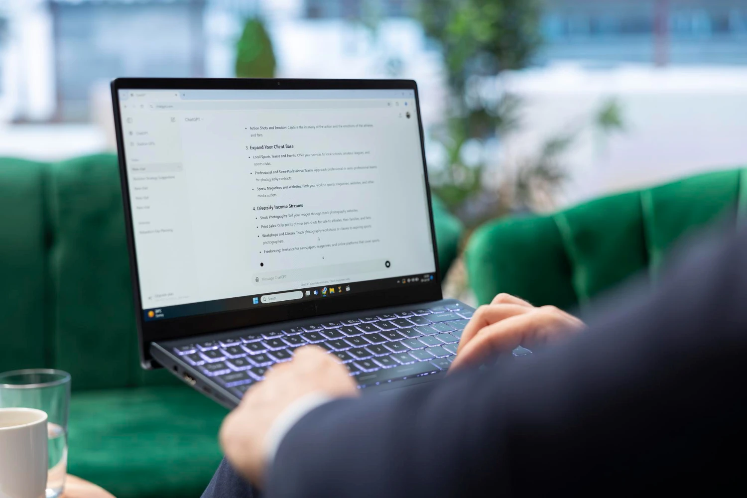 Como Monitorar a Menção da Sua Marca Em ChatGPT, Gemini e Perplexity: Pessoa usando notebook em um ambiente de escritório, digitando enquanto visualiza um documento na tela, com foco na leitura e no monitoramento de informações.